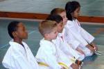 Youths Kneeling Attentively at Karate Lesson